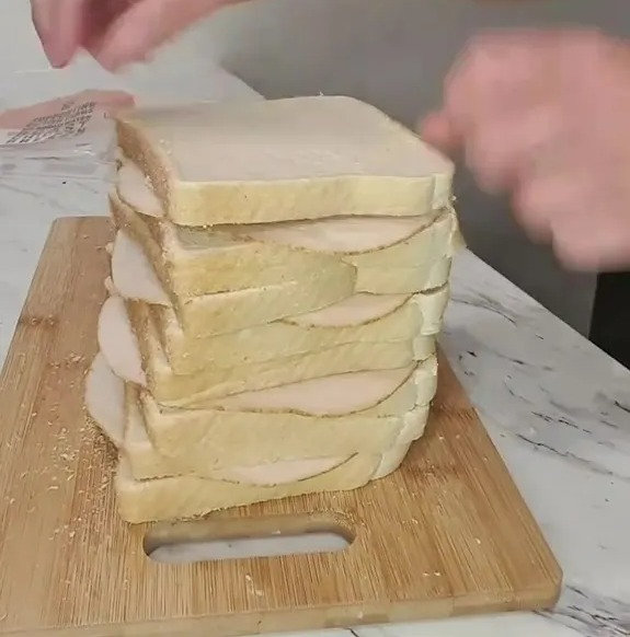 A stack of sandwiches on a cutting board.
