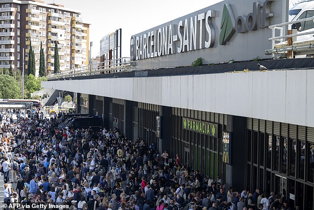 People listen to the radio through the loudspeakers of the headquarters of catalunya radioPeople outside Barcelona Sant rail station during a massive power cut