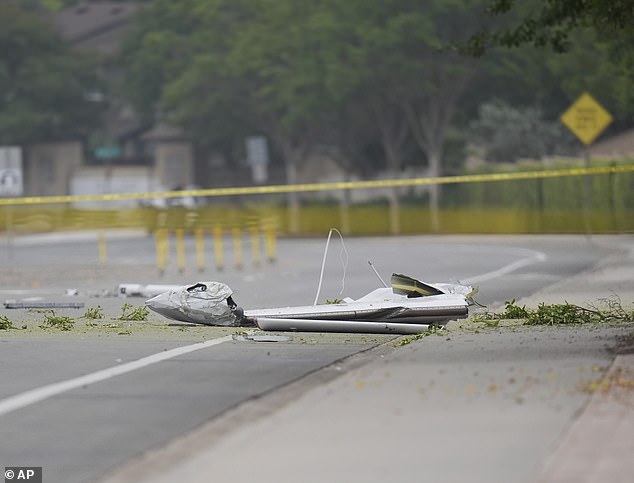 Debris covers the ground after a small plane crashed into a San Diego neighborhood earlier, setting several homes on fire and forcing evacuations along several blocks
