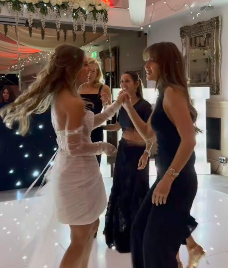Bride dancing with guests at wedding reception.
