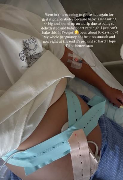 Pregnant person in hospital bed with IV and fetal monitor.