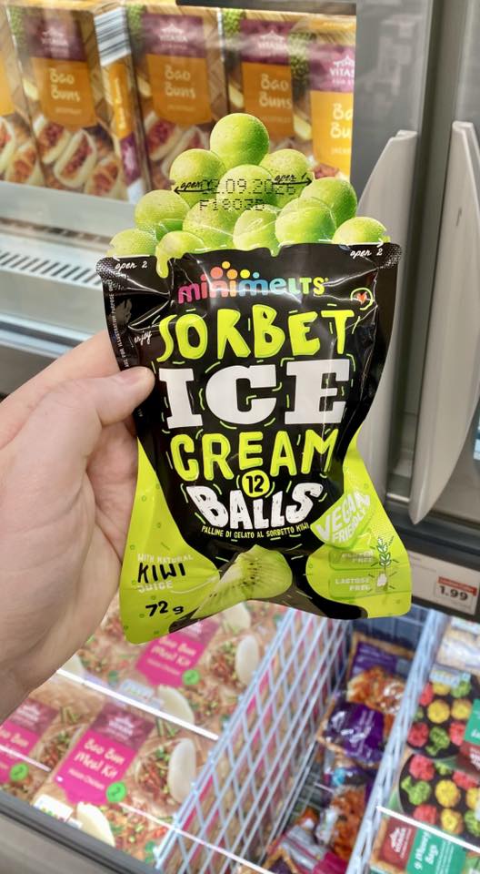Hand holding a bag of kiwi sorbet ice cream balls.