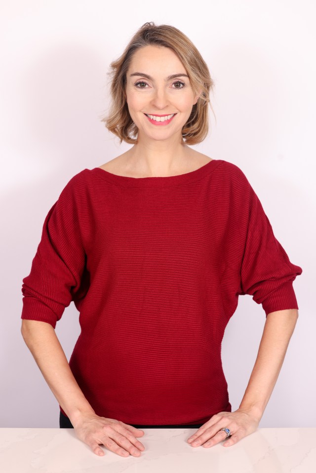 Portrait of a smiling woman wearing a red sweater.