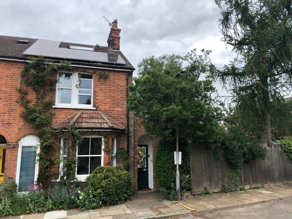 Brick house with solar panels on the roof and a stained-glass door.