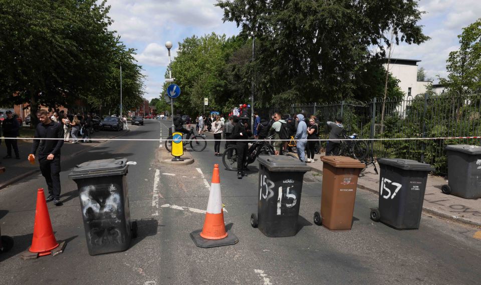 Floral tributes and people gathered on Lower Broughton Road.