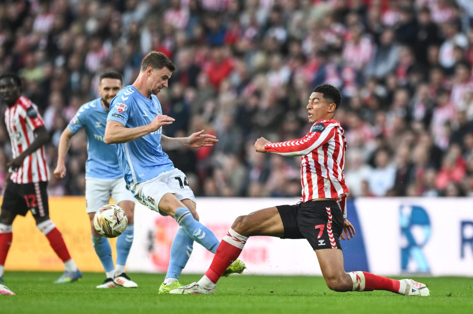 Two soccer players vying for the ball during a match.