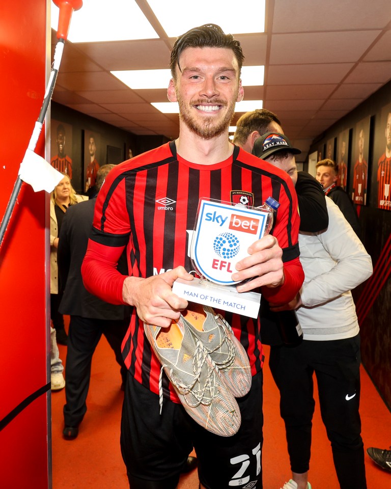 Kieffer Moore of Bournemouth holding his Man of the Match award and soccer cleats.