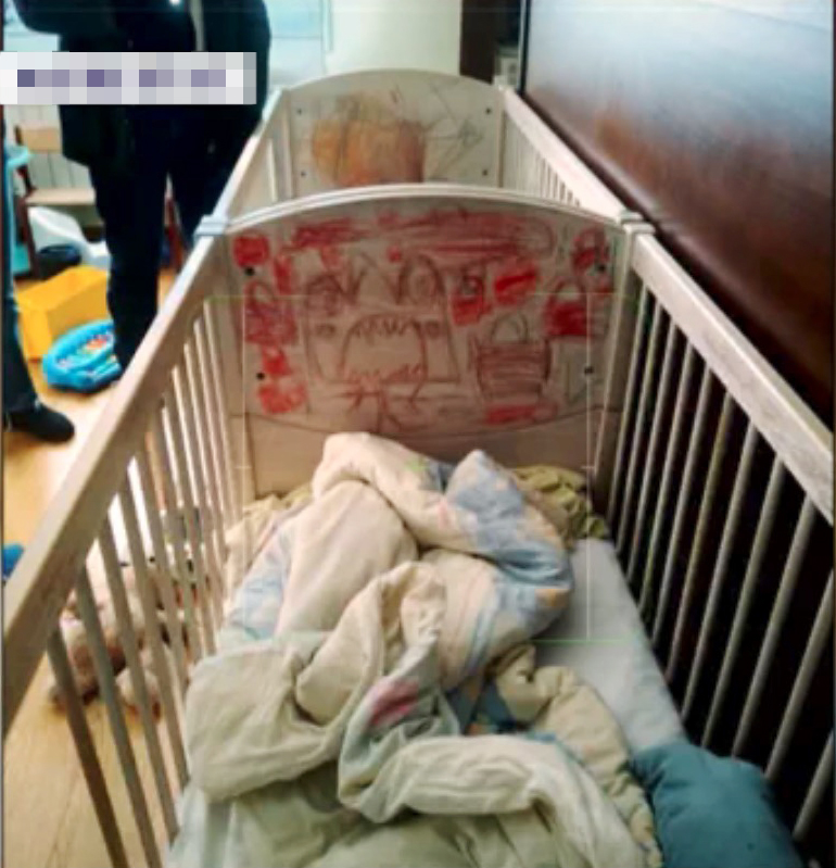 Child's crib with drawings on the side.