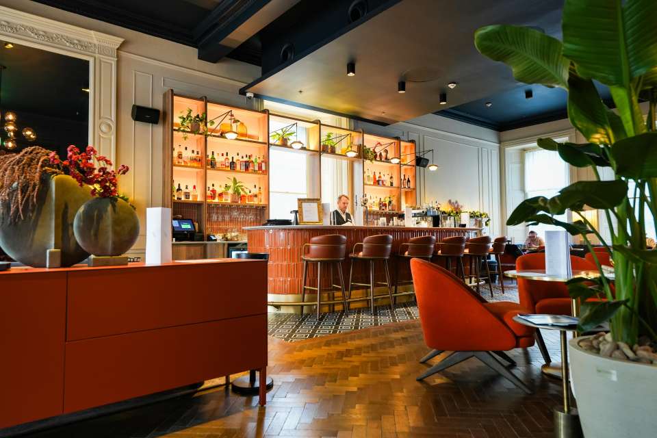 Interior view of a bar with a bartender and patrons.