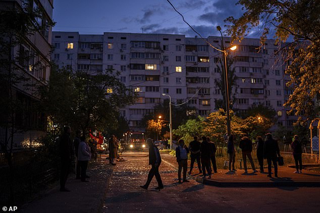 Pictured: Residents walk on a street with pieces of broken glass at the site of a residential building that was damaged after a Russian attack in Kyiv on Saturday, May 24, 2025
