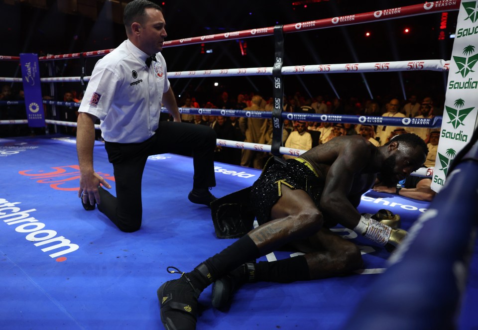Deontay Wilder down on the mat during a boxing match.