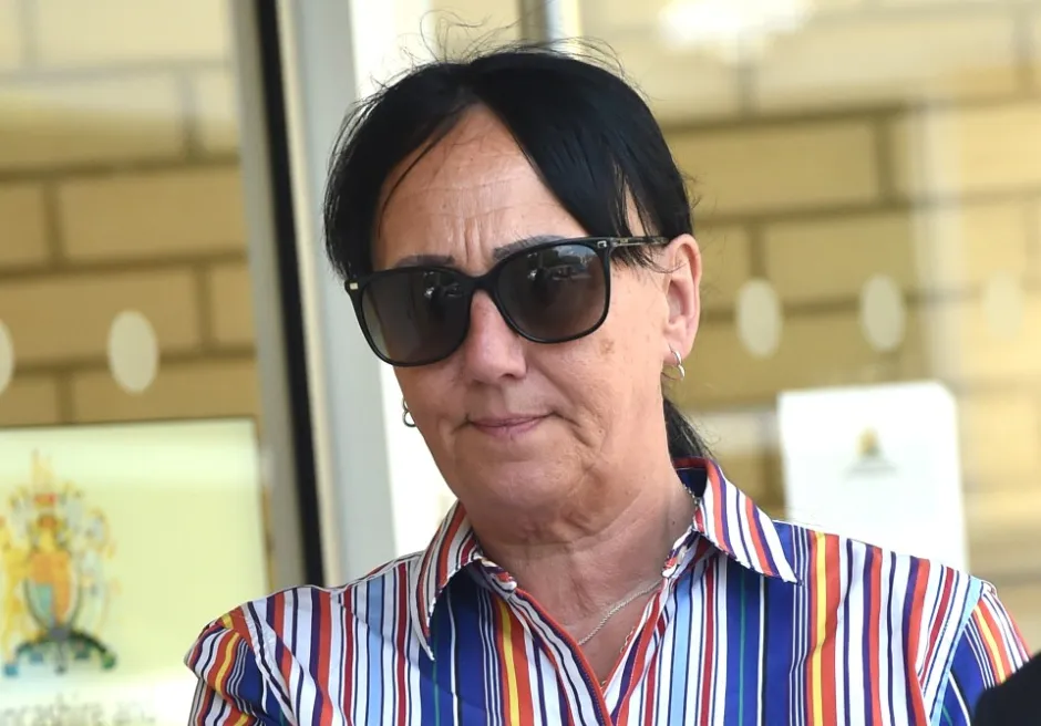 Woman wearing sunglasses and striped shirt.