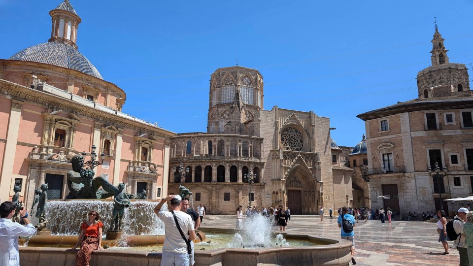 Valencia square with a fountain and cathedral in the background.