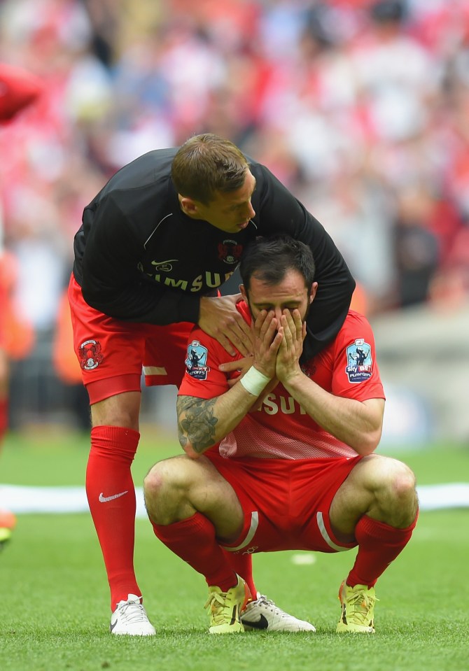 A distraught soccer player is comforted by a teammate after a missed penalty shot.