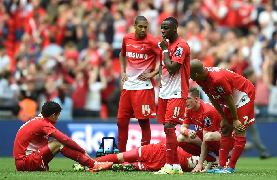 Dejected Leyton Orient soccer players on the field after a match.