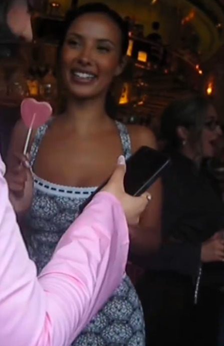 Maya Jama holding a heart-shaped lollipop.