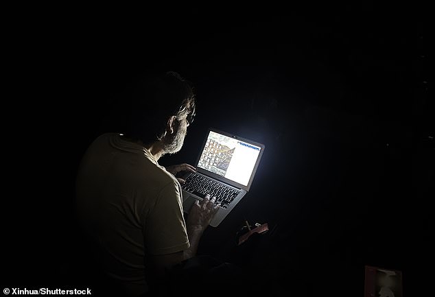 A journalist works on his laptop following the power outage today, that also brought disruption to the Cannes Film Festival