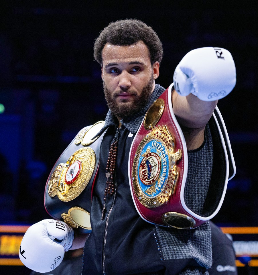 Moses Itauma, boxing champion, wearing championship belts.