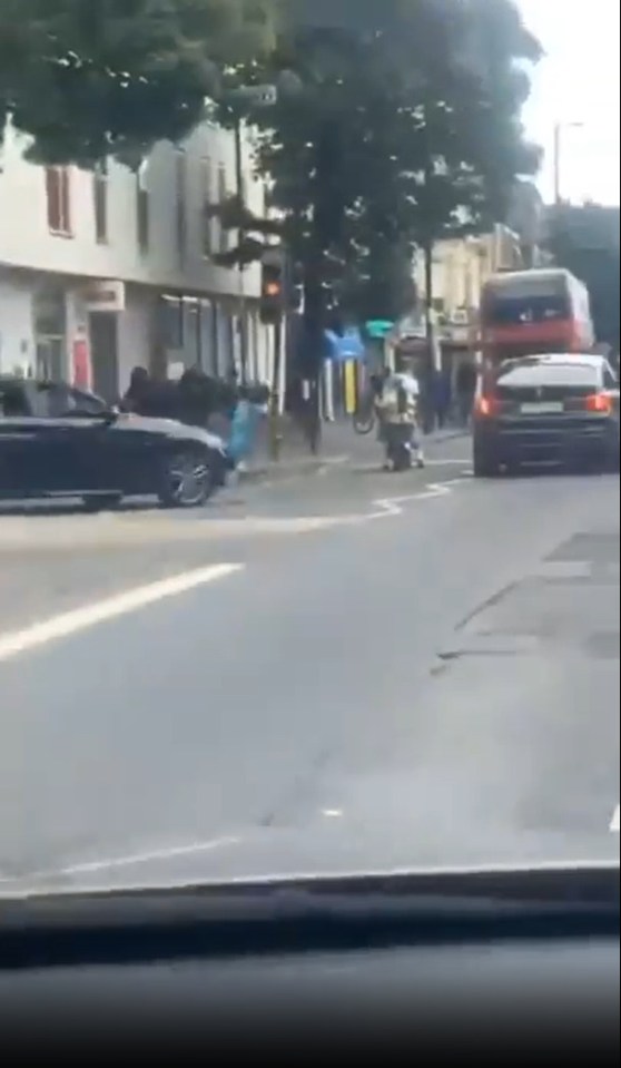 Street brawl where a driver runs over a cyclist.