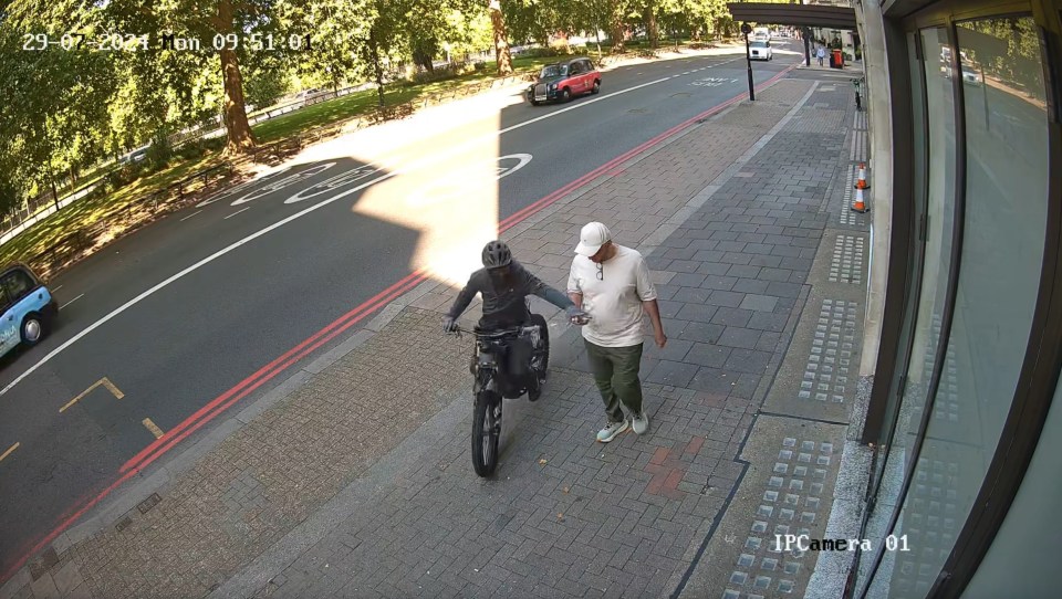 CCTV image of a thief on an electric bike stealing a man's phone.