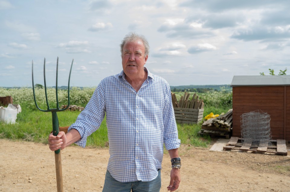 Jeremy Clarkson holding a pitchfork on a farm.
