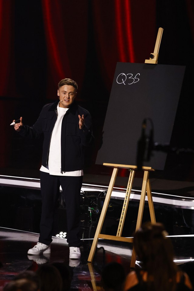 Harry Moulding on Britain's Got Talent, holding a marker and standing in front of an easel with "Q35" written on it.