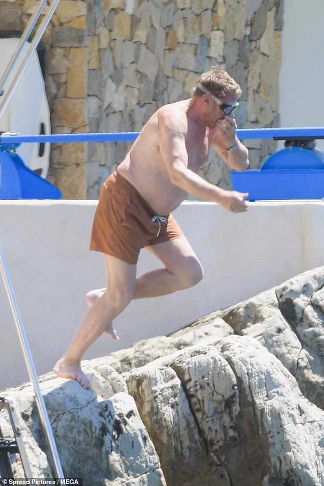 Simon was then seen bracing himself from the cliff edge as he jumped into the ocean