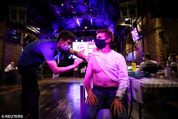 A person receives a dose of the Pfizer BioNTech vaccine at an NHS vaccination centre hosted at the Heaven nightclub