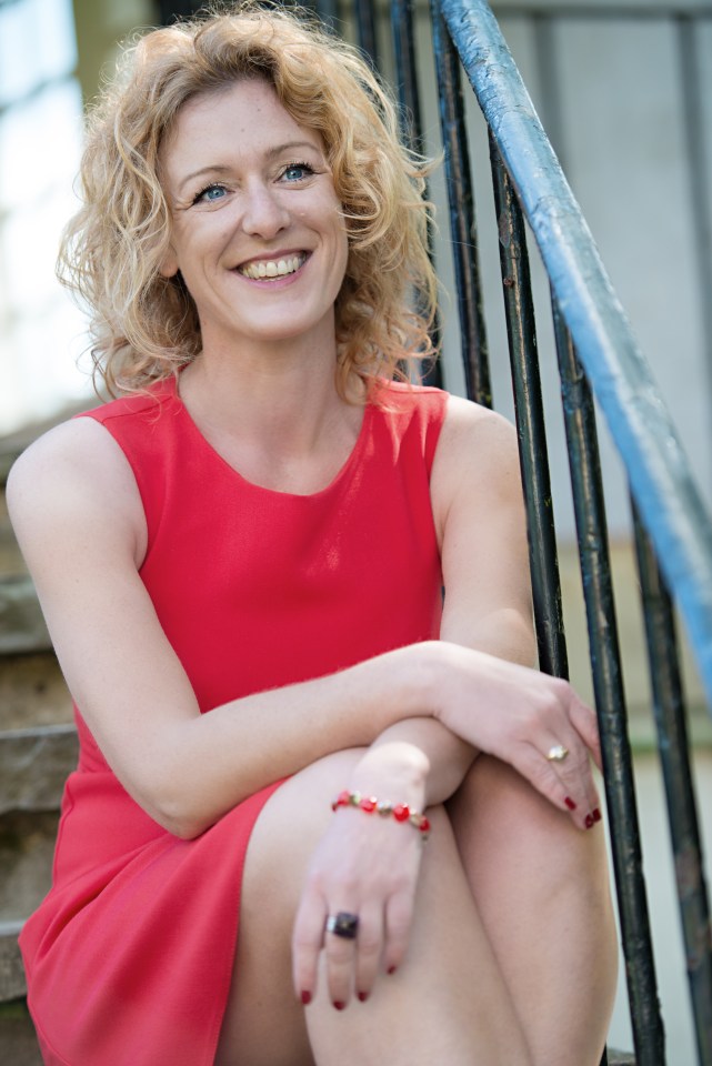 Woman in red dress sitting on steps.