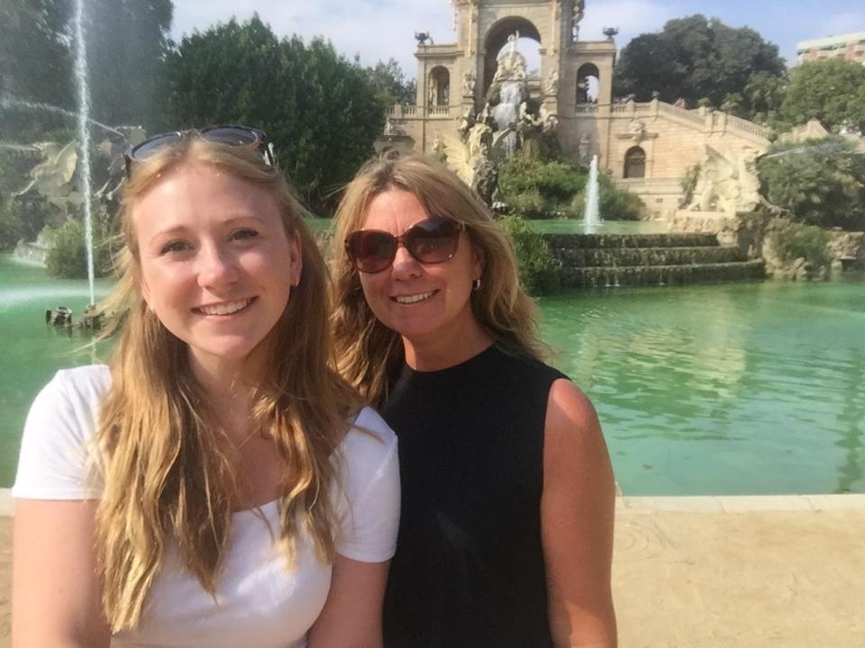 Two women posing in front of a fountain.