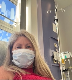 Woman in hospital room wearing a face mask.