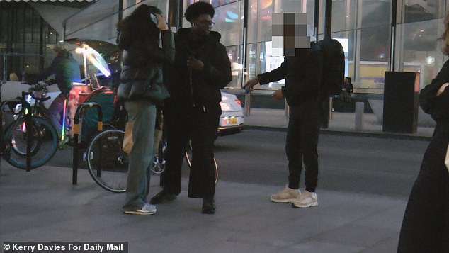 Two pedestrians can be seen standing by the bike and the man appears to have a quick word with them