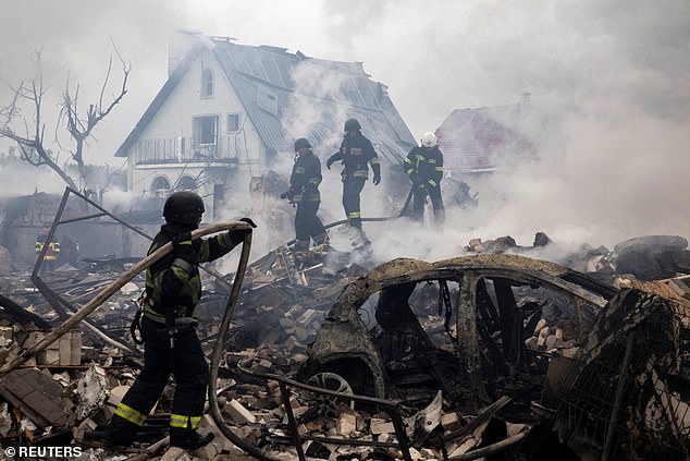 Emergency workers extinguish fire in the debris of a private house that was destroyed in a Russian rocket strike