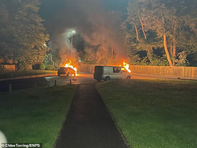 Another vehicle and a van are seen engulfed in the flames during the attack which caused £170,000 in damages