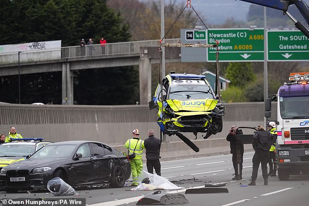 Pictured: A severely damaged police car at the scene of the crash