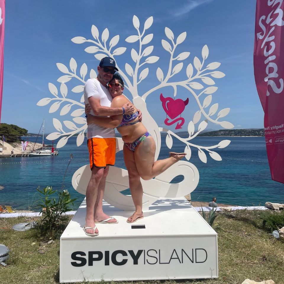 Couple hugging in front of a SpicyIsland sign.