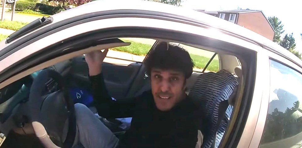 Video still of a man in a car during a traffic stop.