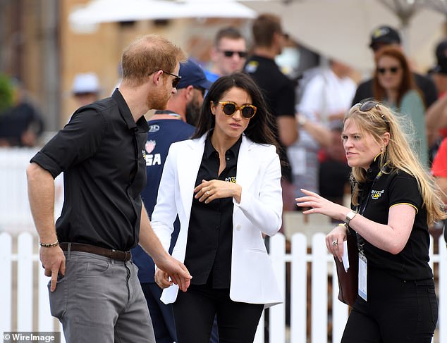 Prince Harry and Meghan with her assistant Amy Pickerill in Sydney. A royal insider has revealed that behind the glittering success of the tour tensions were already starting to rise between the couple and their royal aides
