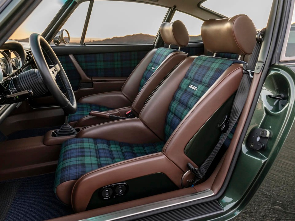 Interior view of a Porsche 911 with plaid seats.