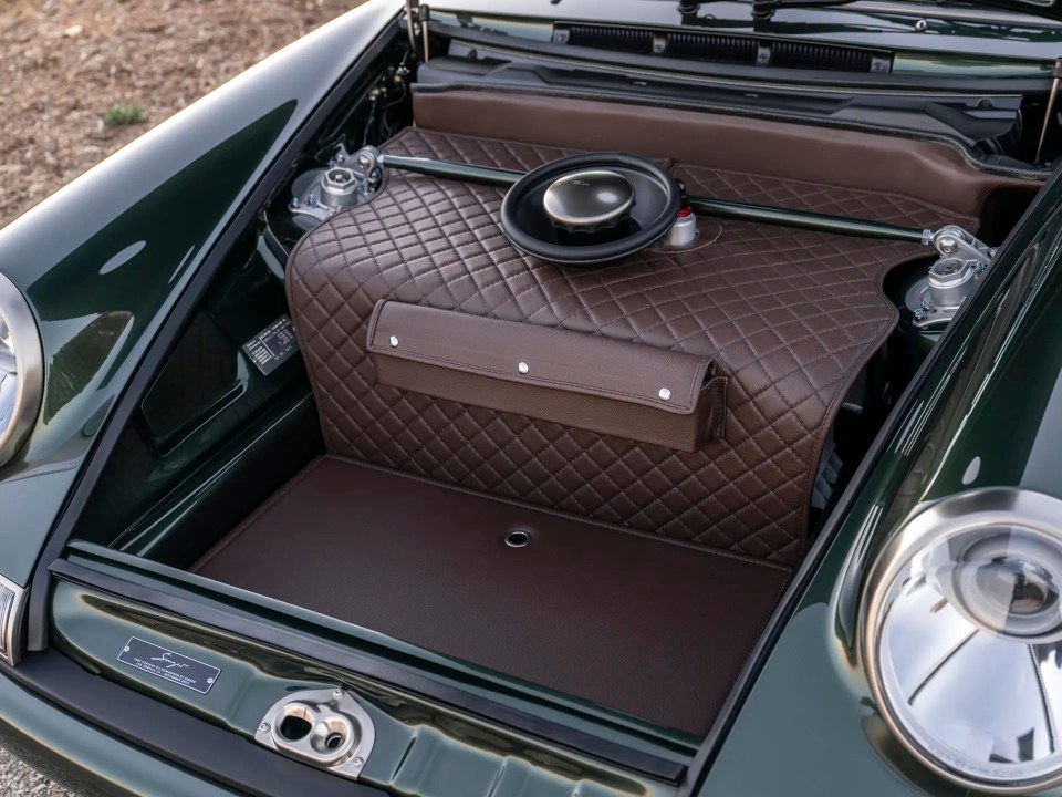 The trunk of a customized Porsche 911, showing brown leather interior details.