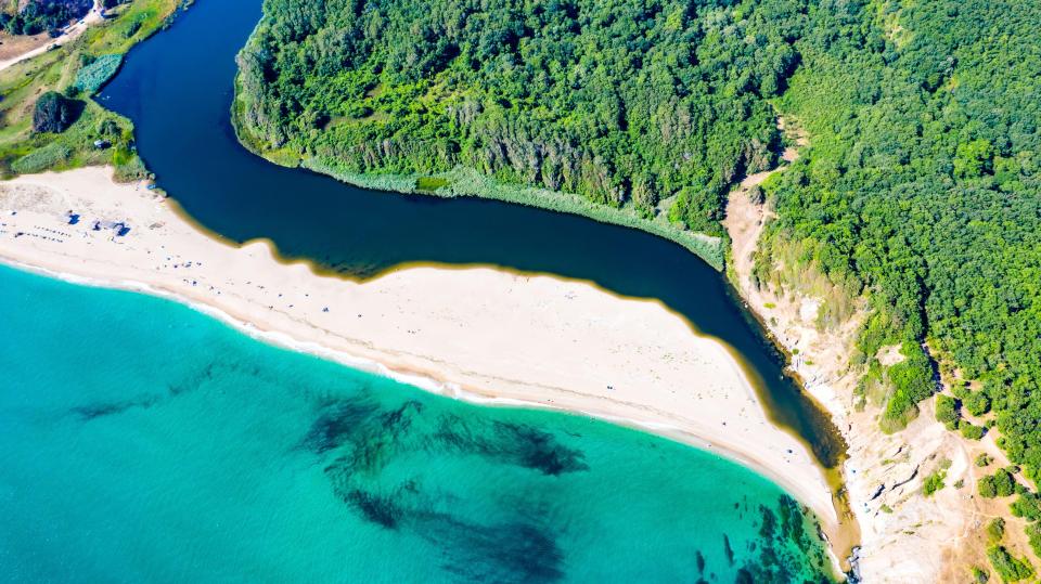 Aerial view of Veleka Beach in Bulgaria, showing a river meeting the turquoise sea.