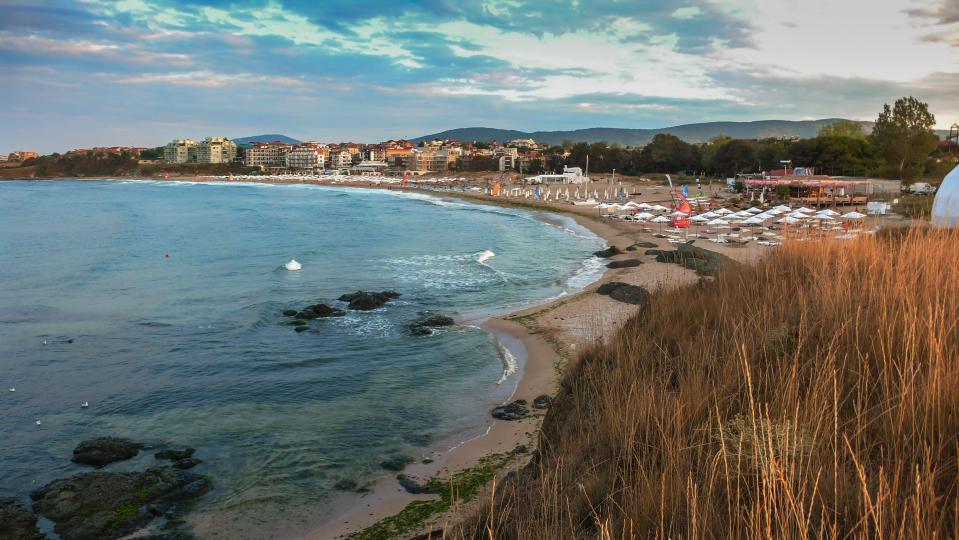Seascape of Lozenets coastline with beach umbrellas and buildings.