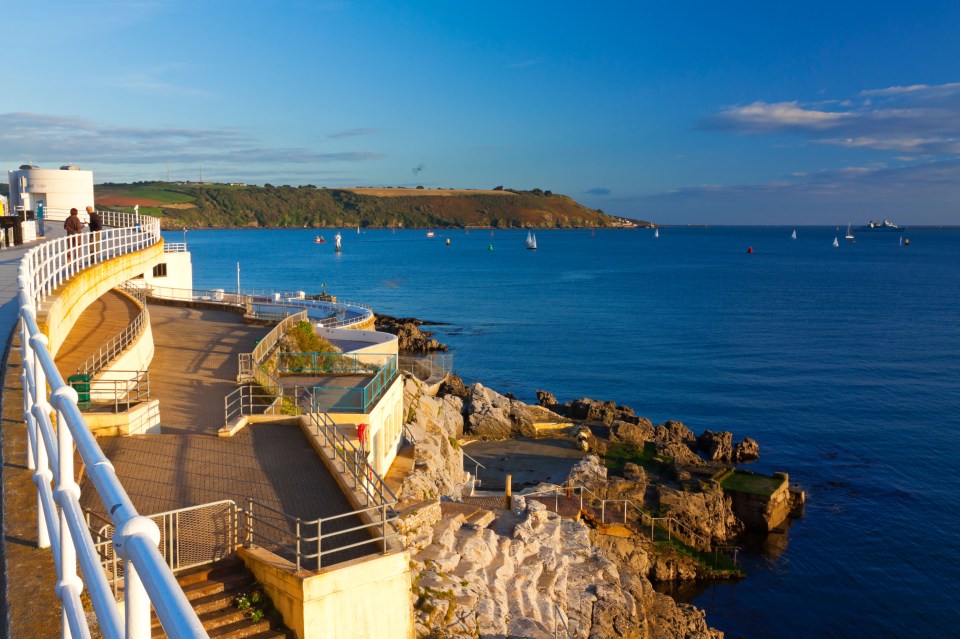 Outdoor swimming pool and walkway overlooking the sea.