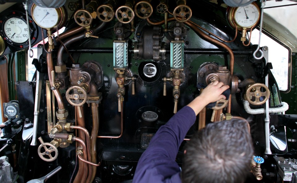 Interior view of a steam locomotive's cab, showing its controls and gauges.