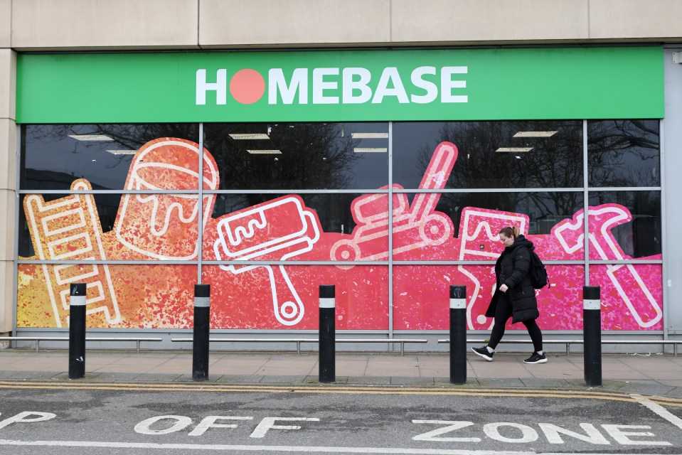 Woman walking past a closed Homebase store.