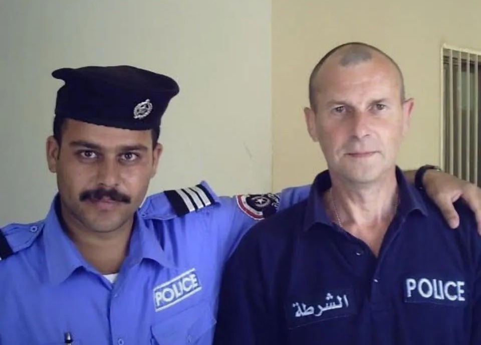 Two police officers, brothers with different career paths, posing for a photo.