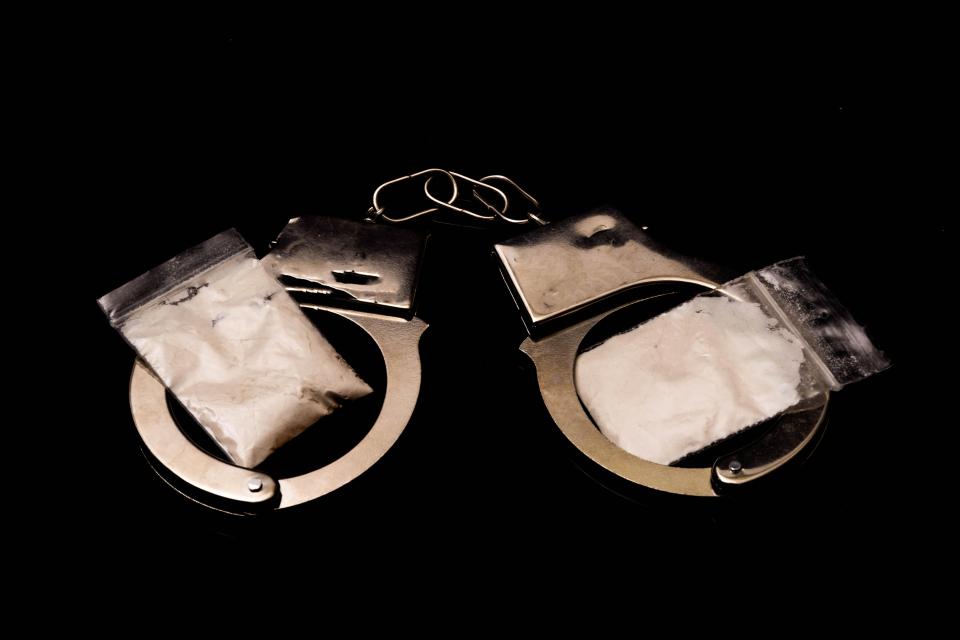 Handcuffs with bags of white powder.