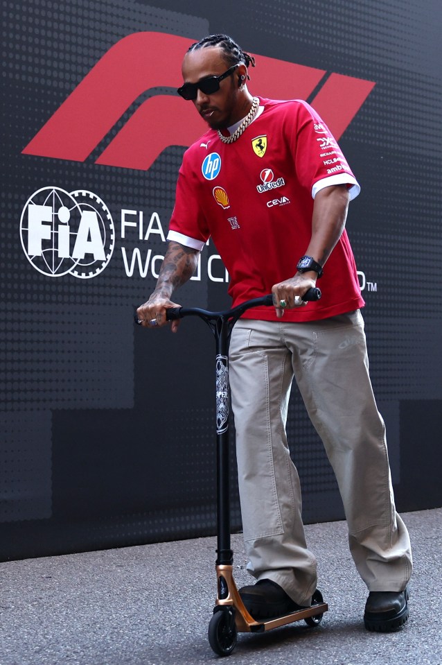 Lewis Hamilton riding a scooter before a Formula One race.