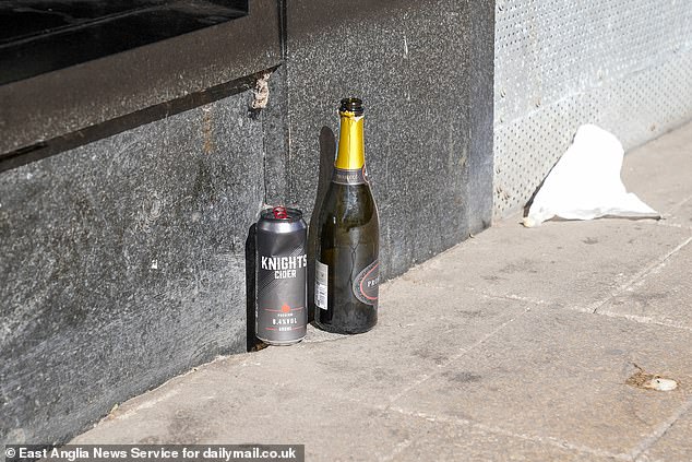 A bottle of prosecco and cider next to rubbish left outside Norwich's Debenhams