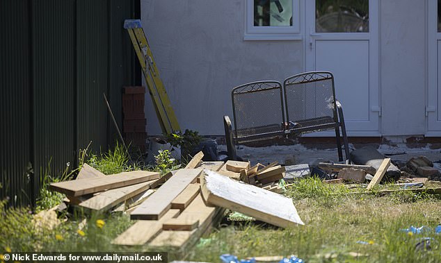 The garden next door was littered with building materials when MailOnline visited it